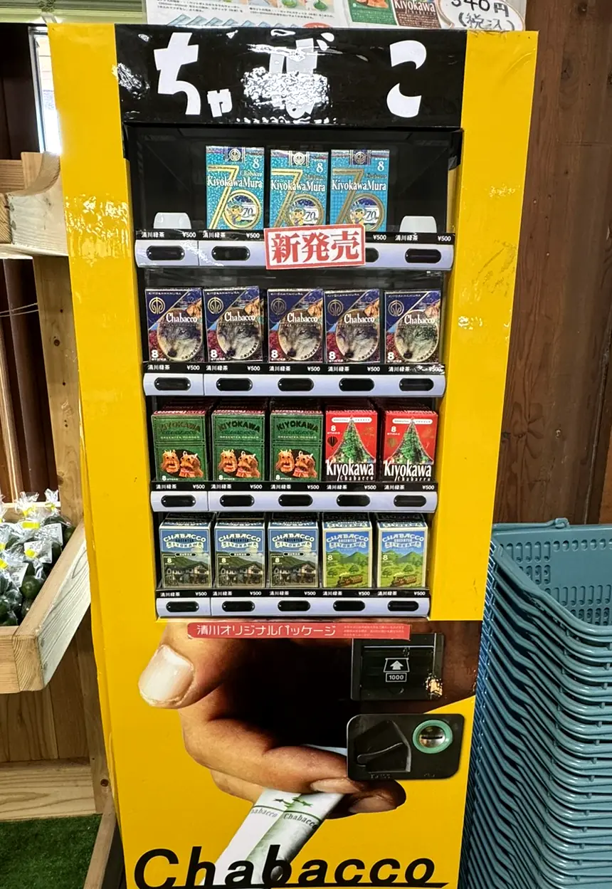 黄色い自動販売機に、ちゃばこの箱がずらりと並ぶ(写真)