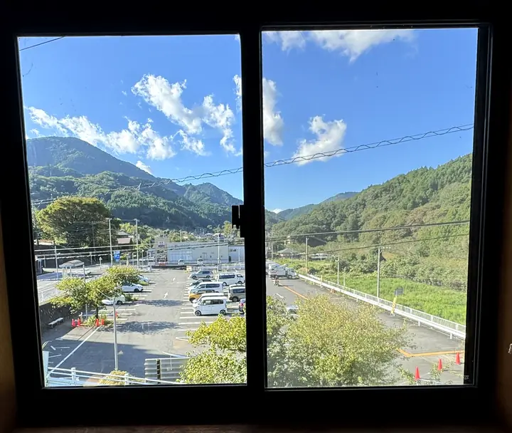 2階の窓から見た山と駐車場(写真)